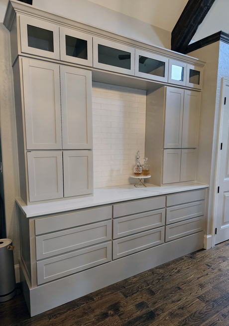 Gray custom-made built-in cabinetry with upper and lower storage and a central open space.