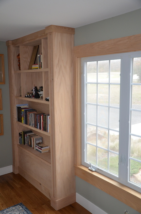 Wooden custom made bookcase/cabinet against wall.