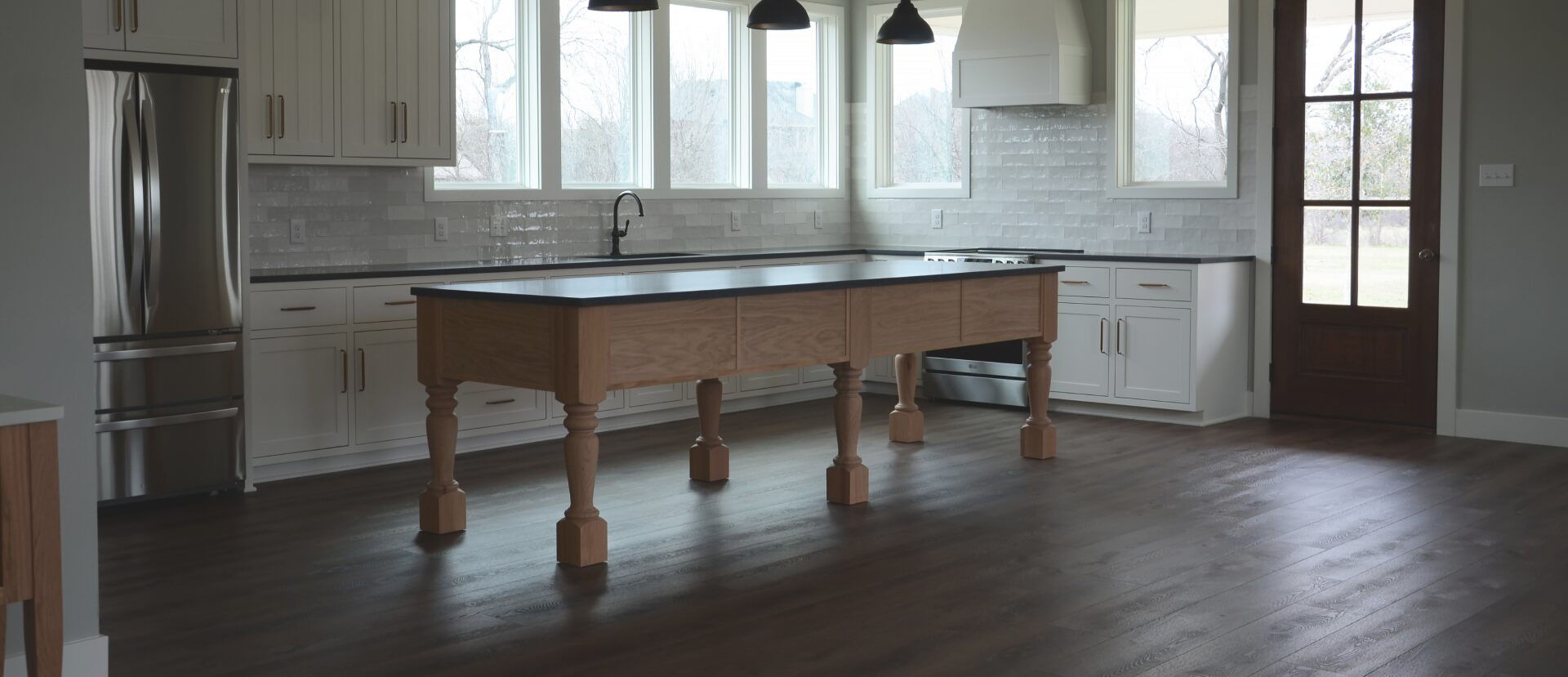 a full kitchen remodeling with custom cabinets and a long center island by renovacraft